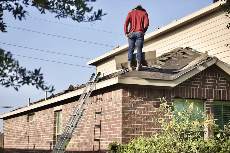 Professional roofer working on a residential roof in Vincent